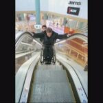 Ride down an escalator in a wheelchair with assistance
